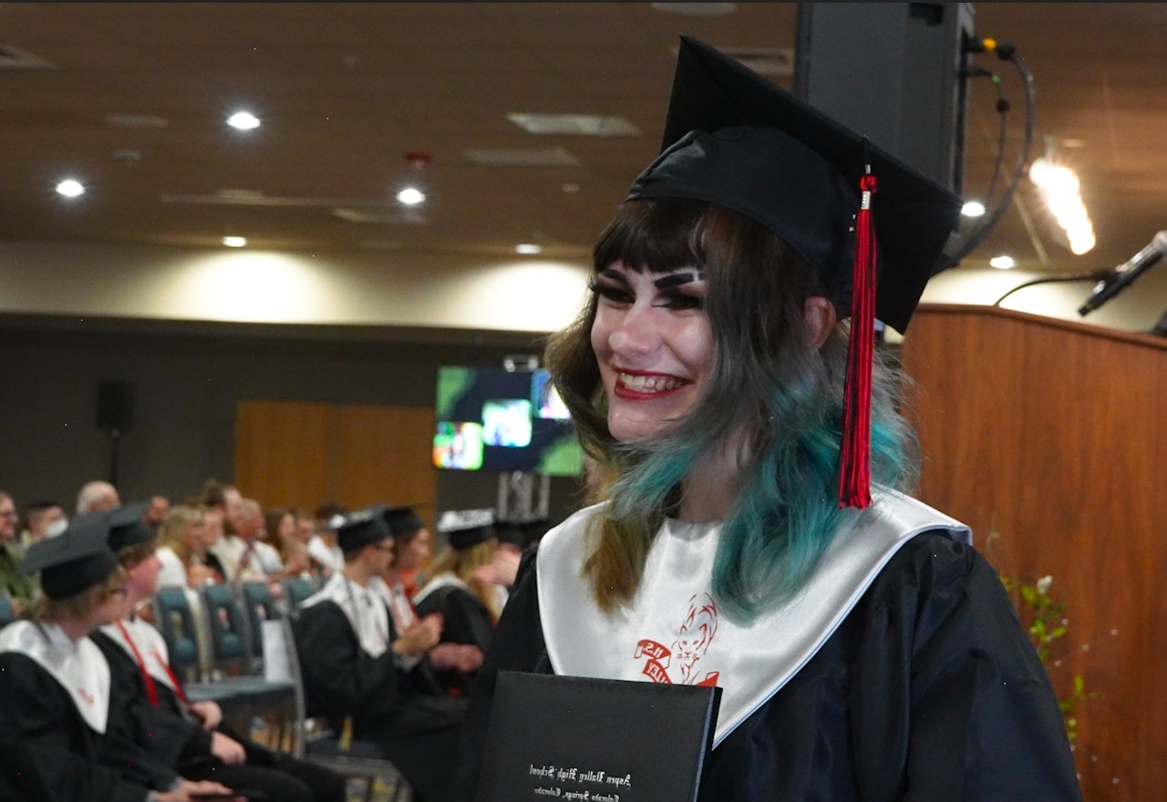 An AVC student smiles while receiving her diploma at the 2023 graduation ceremony.